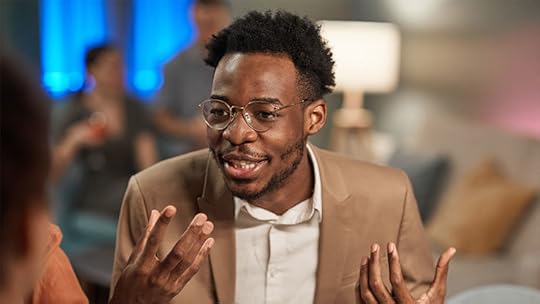 young black man speaking with a smile and gesturing with his hands