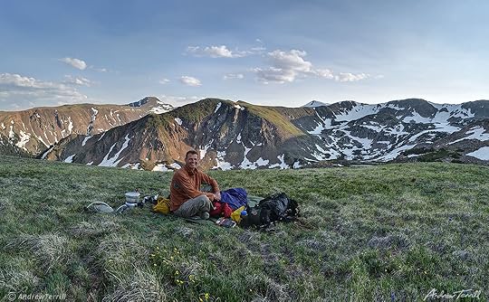 andrew terrill sitting on hillside in rocky mountains