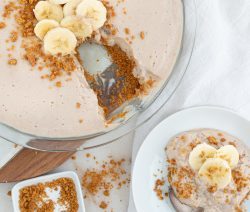 banana cheesecake with one slice on the side with a white background