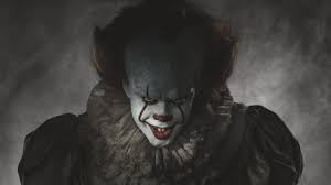 Pennywise the Clown staring malevolently out at the viewer with a sinister smile on his face.