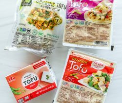 four different packaged tofu blocks on a white background