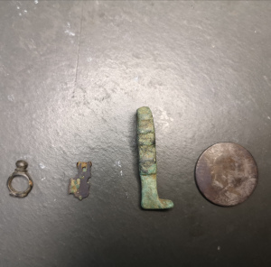 left to right, a bit of strap … something, a harness mount in partifact, a leg made from pure green and a bull head florin.