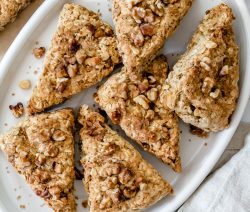 6 walnut scones in a white tray with a white background