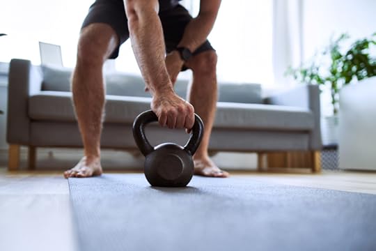 Closeup of man grabing kettlebell during home barefoot workout exercises