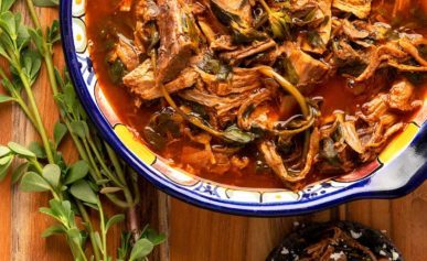 A bowl of puerco con verdolagas, pork with purslane