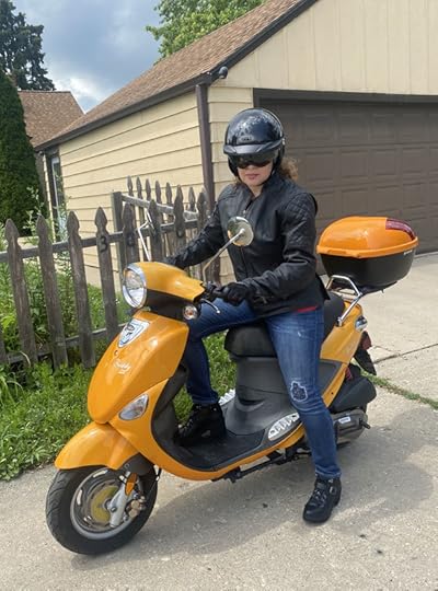 Photo of Silvia Acevedo on a bright orange Genuine Buddy 125cc scooter