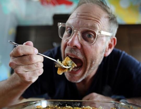 Celebrity Chef Alton Brown eating a big hunk of cornbread dressing