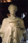 A priestess carries a sacred vessel in veiled hands