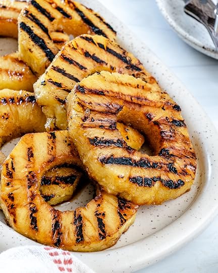 sliced grilled pineapples on a white tray in a white background