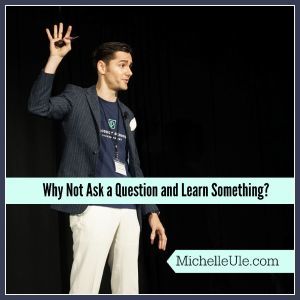 man raising hand to ask a question