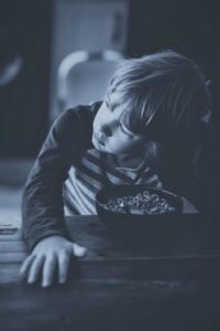 Boy eating Cheerios and pondering a question.