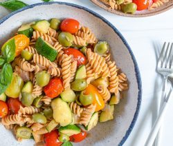 white plate of pasta with veggies