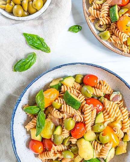 white plate of pasta with veggies in a white background