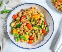 white plate of pasta with veggies