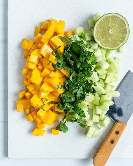 ingredients of mango cucumber salsa in a white background