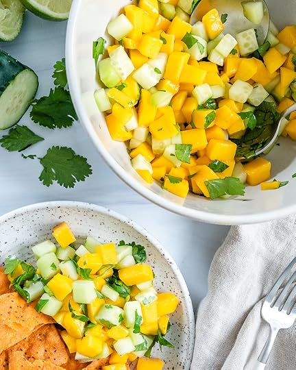 two white bowls with mango cucumber salsa in a white background