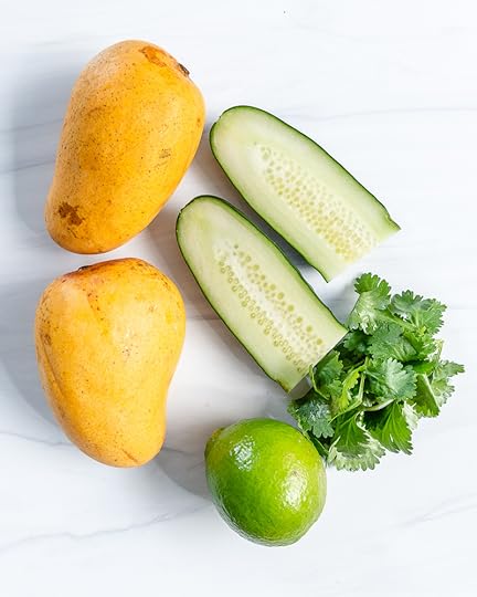 ingredients of mango cucumber salsa in a white background