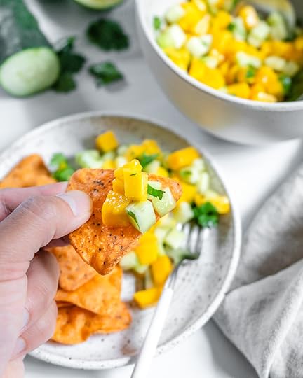 two white bowls with mango cucumber salsa in a white background