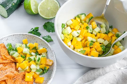 two white bowls with mango cucumber salsa in a white background