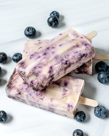 plate of blueberry popsicles with blueberries in the background
