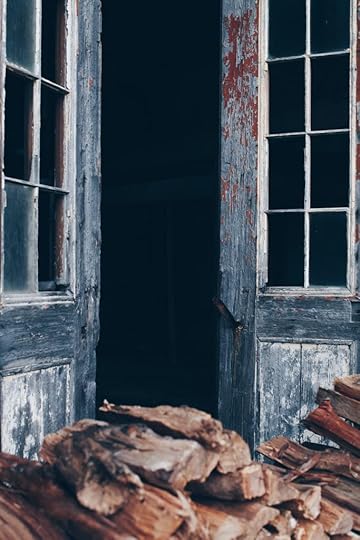 An aging, peeling door opens into a dim room.