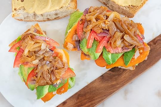 sweet potato and avocado sandwich with multiple layers of ingredients on a white tray with a white background