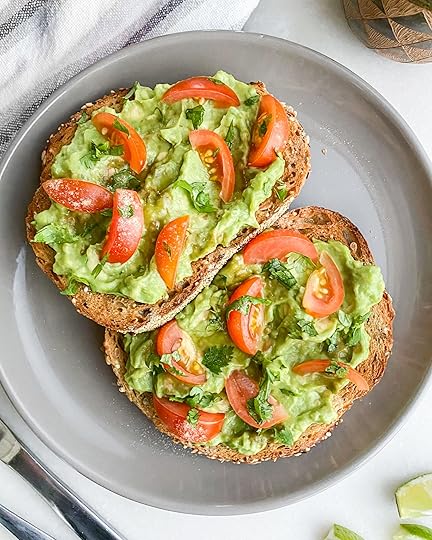 two slices of avocado toast with tomatoes on a gray plate
