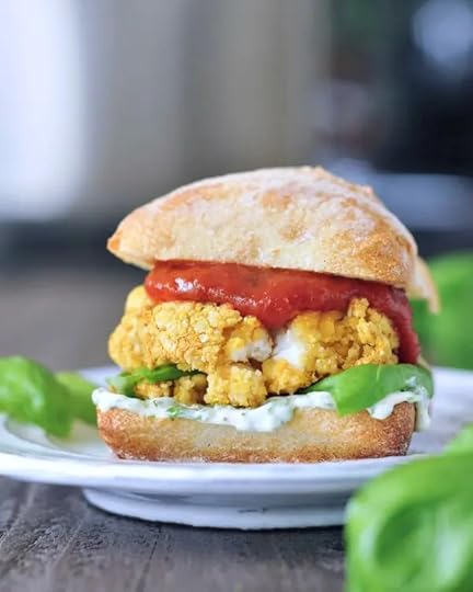 Mozzarella Stuffed Vegan Chicken Burger on a white plate with greenery in the background