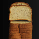sliced sandwich bread on black table top.