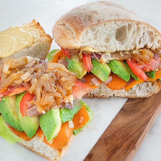 two sweet potato and avocado sandwiches on cutting board