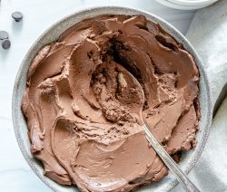 white bowl of chocolate mousse with chocolate chips in a white background