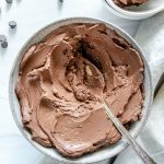 white bowl of chocolate mousse with chocolate chips in a white background