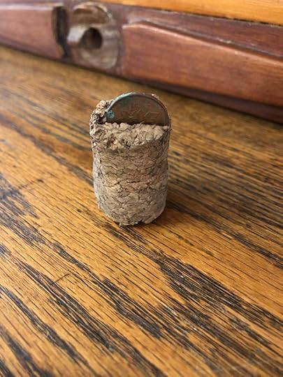 Photo of a cork with a penny in it.
