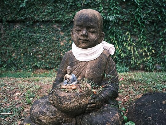 statue of buddha holding a small statue of buddha