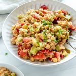 white plate of chickpea salad in a white background