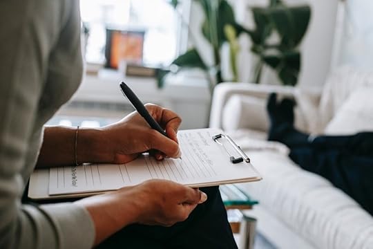 Image: therapist making notes while patient lies on sofa