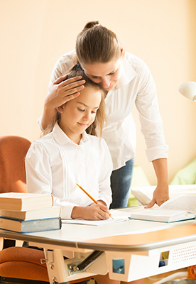 A mom offers a comforting and encouraging hug as her daughter works on school work. The motivational back to school quotes in this article can help us focus on positive things during challenging times.