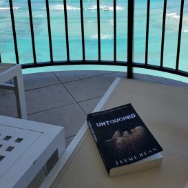 Untouched book on lounge chair overlooking Pacific in Hawai'i