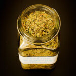 closeup of homemade Italian seasoning in an open spice jar.
