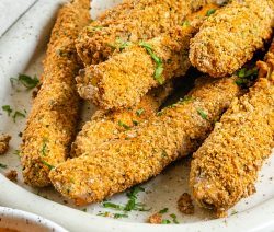 several baked zucchini fries on white platter