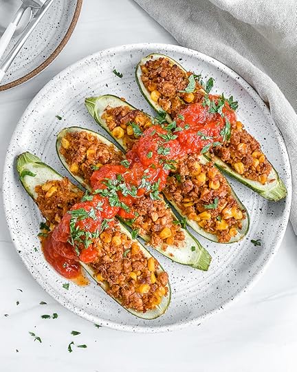 4 tex mex zucchini boats on white plate with white background