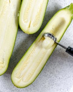 process of making zucchini boats on white granulated backgorund