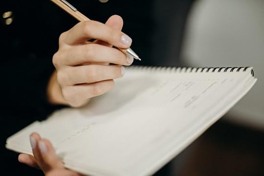a girl is writing in her notebook