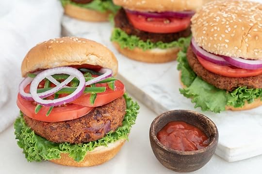 Four red beans spicy vegan burgers with a bun and veggies