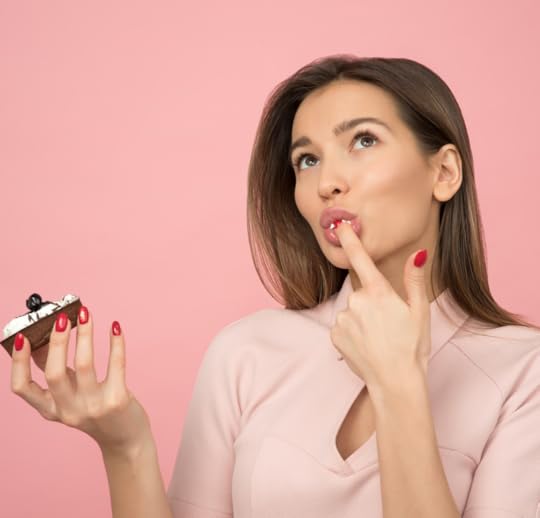 A young woman eating a cupcake.