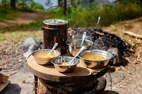 Lunch break at camp. Cooking simple delicious soup on fire, serving in touristic metal bowls. Concept of food preparation in travelling, camping, trekking, hiking trips. Bowler pot on background, backpacking food