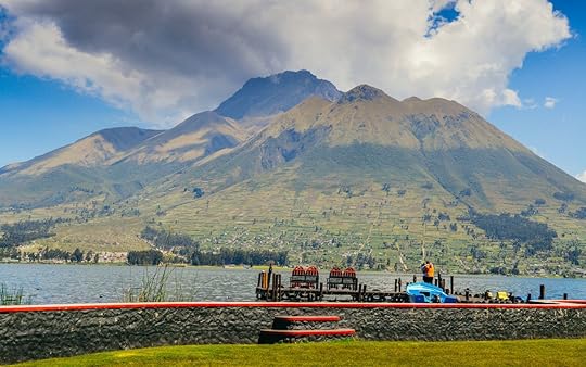 A couple hugs in front of San Pablo Lake, with the volcano in background in Ecuador