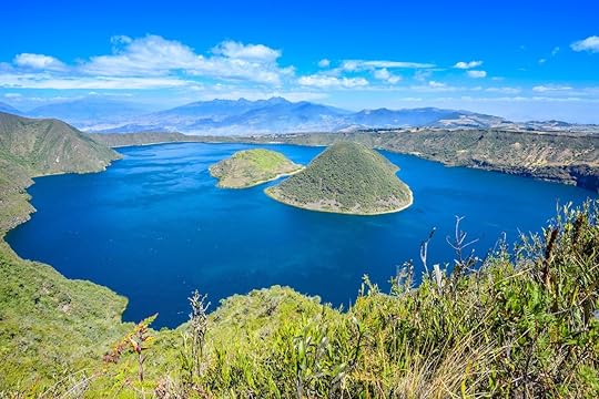 Cuicocha Crater Lake with its islands in the middle and bright blue water with bright blue sky