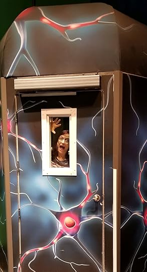 Sharon trapped inside a time machine with frightened face and hands pressed against the window.