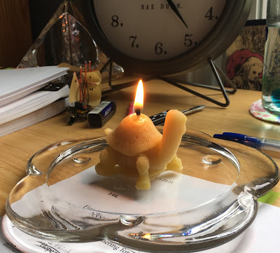 Small turtle-shaped yellow beeswax candle on my writing desk.
